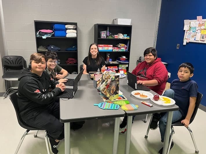 Heather Reagan, site coordinator for Danville Middle School, sits with a group of students.  