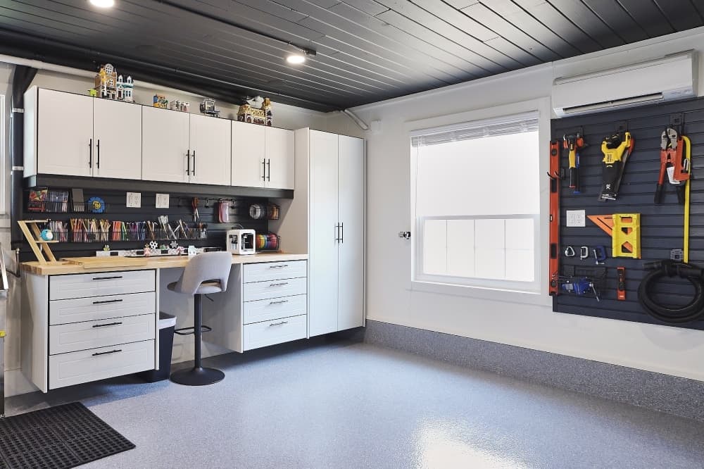 A newly converted garage with a full workshop space and cabinets 