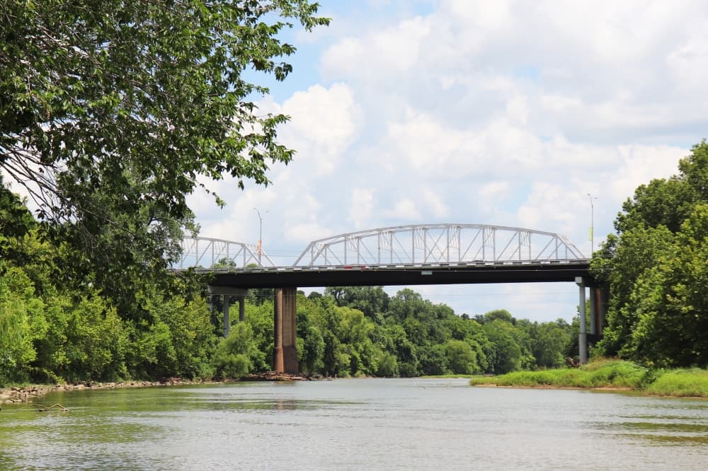 Old river bridge surrounded by trees.