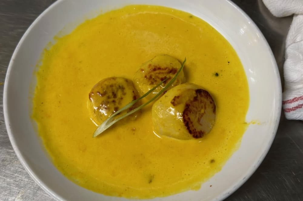 Pan seared Scallops in a creamy sauce with chives and saffron.