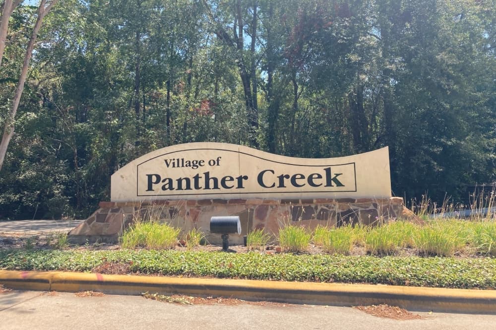 sign that says village of panther creek