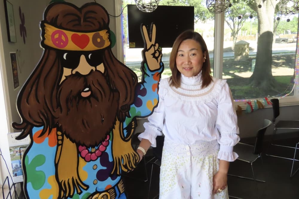 Owner posed next to the doughnut dude at Peace, Love and Little Donuts in Southlake. 