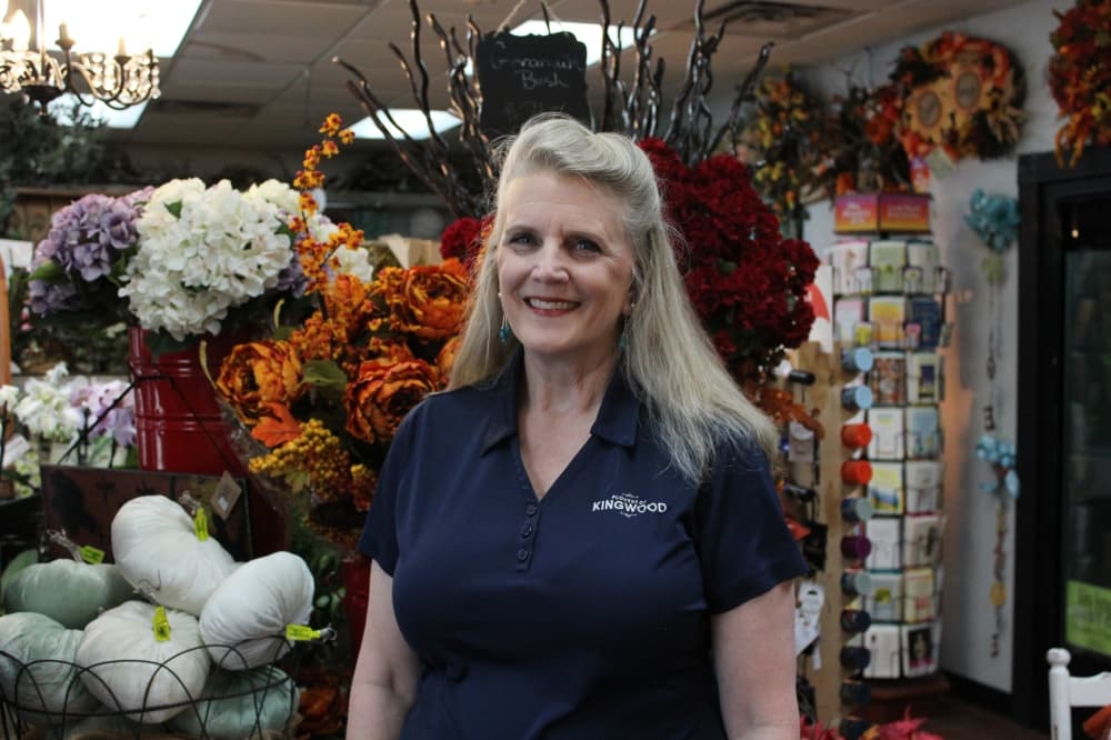 The photo shows Robin Martinez in her store, Flowers of Kingwood.