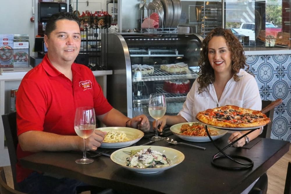 husband-and-wife team, Carmen Silva and Jaime Gama sit at Russo's New York Pizzeria Morton Ranch table in Katy
