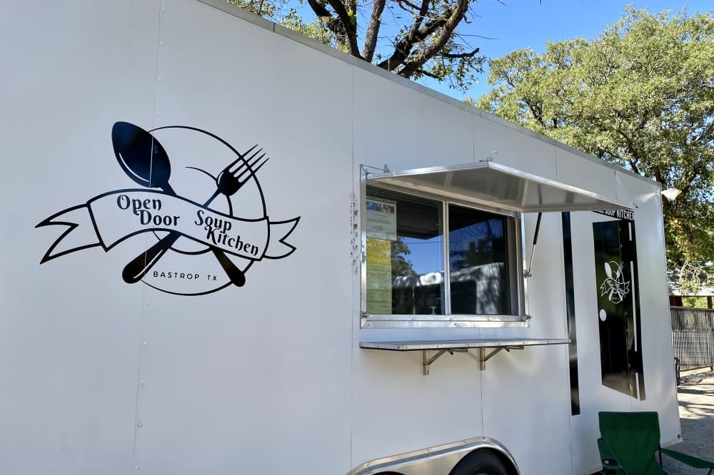 White food truck reading "Open Door Soup Kitchen." 
