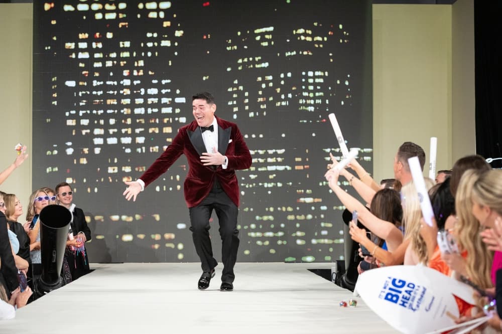 A man walks down a runway in a suit