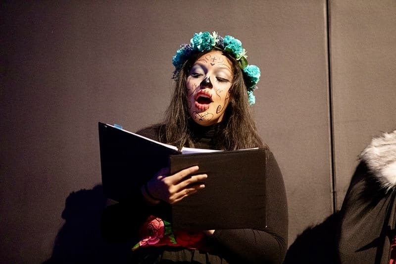 Girl singing with Dia de Los Muertos face painting