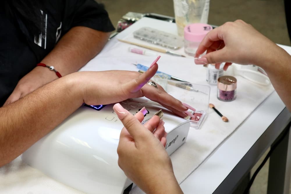 Students ar CTBC in Round Rock practice giving each other acrylic nails