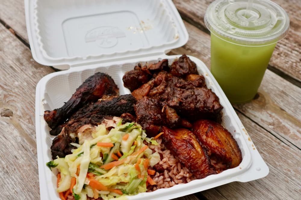 Jerk chicken and oxtail served with steamed veggies, rice, peas and plantains.