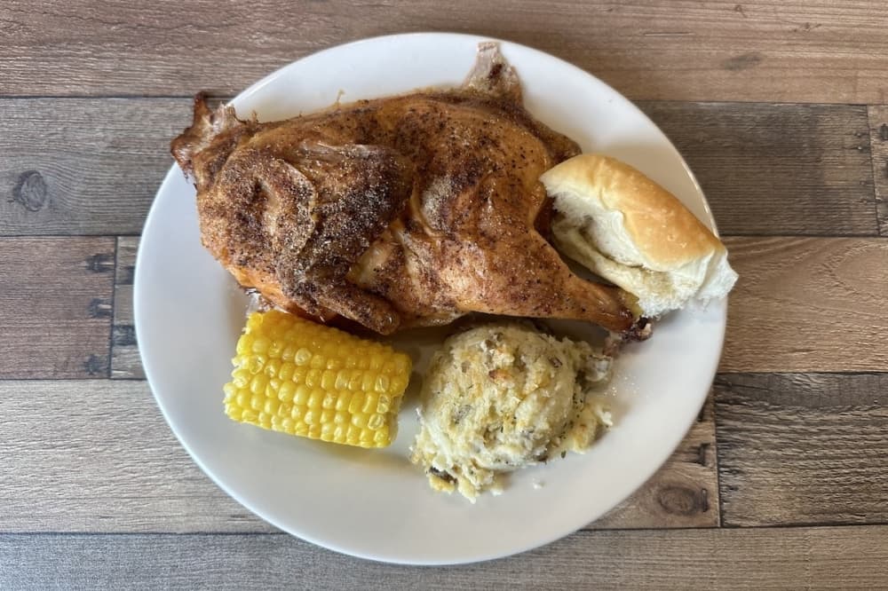 Local Joe's Kitchen oven roasted chicken with a roll, corn on the cob and a side of twice baked mashed potatoes. (Amira Van Leeuwen/Community Impact)