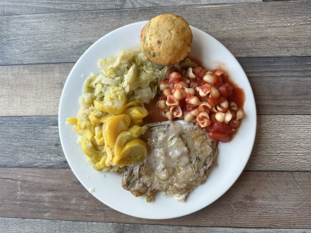 Crawfish chili with tomato macaroni, a side of cabbage, twice baked mashed potatoes and a Jalapeno roll. (Amira Van Leeuwen/Community Impact)