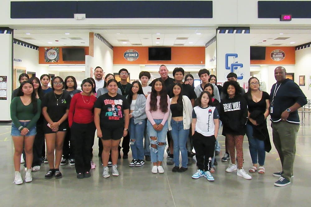 High school students and chefs smile for a group photo.