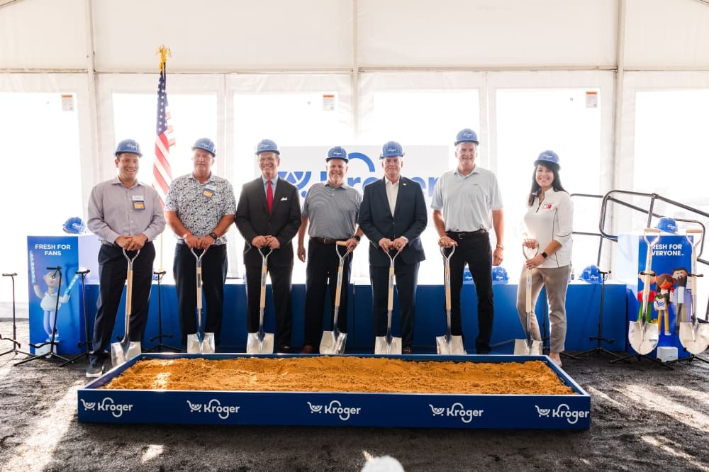 a group of people stand with shovels
