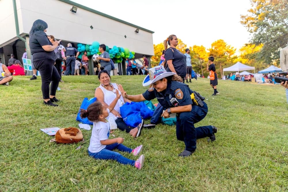 Kid at National Night Out event shaking hands with officer.