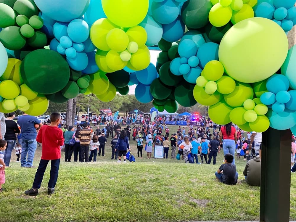 Blue and green balloons framing the NNO event filled with people