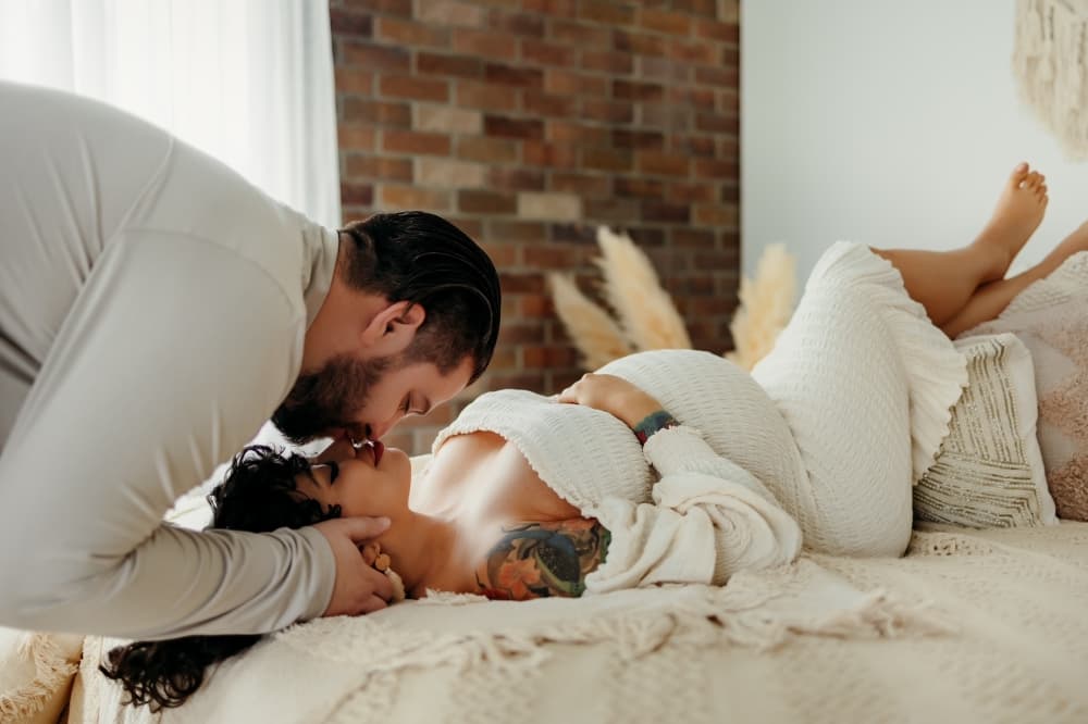 Pregnant woman in white dress at studio photo shoot