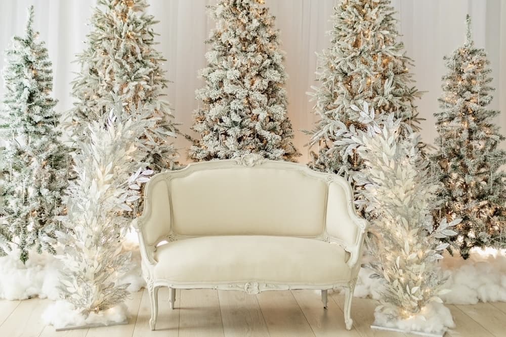 Christmas season-themed set with white couch and white Christmas trees