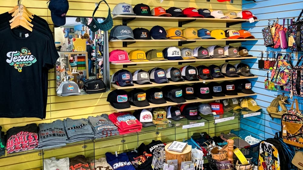 Store shelves with hats and t-shirts.