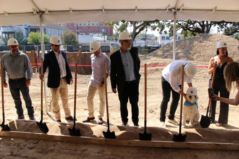 Officials behind the development of the hotel break ground, alongside Daphne the dog.