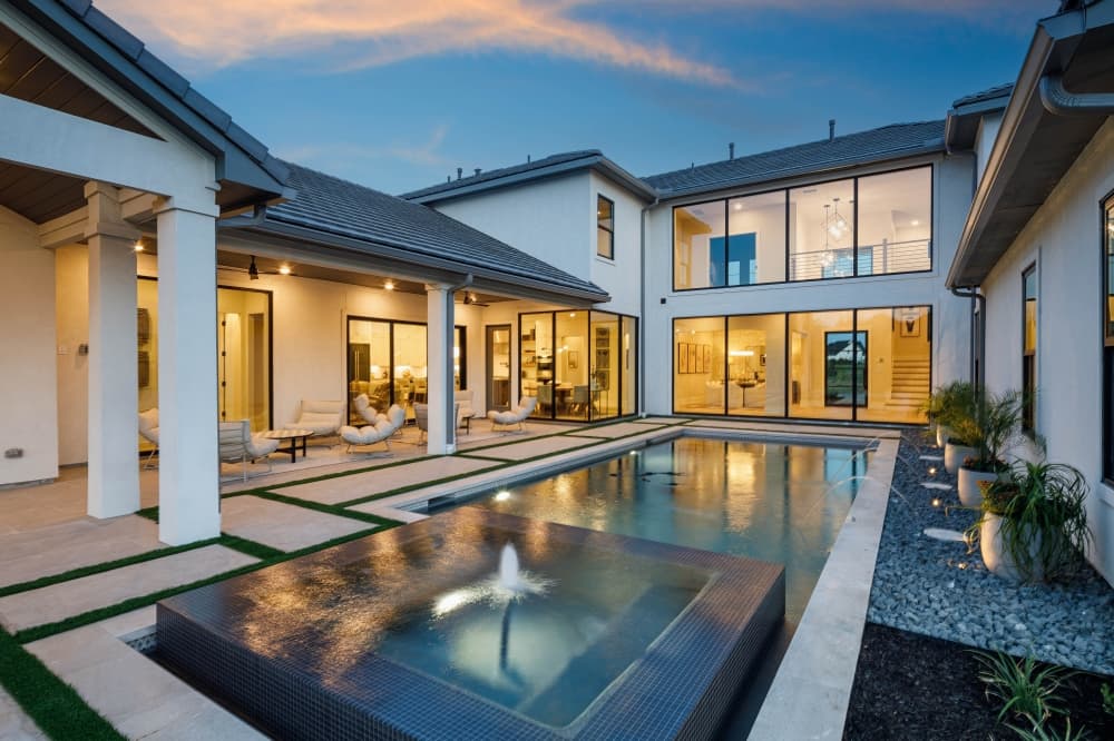An image of the model home's extended patio with a water feature in front.