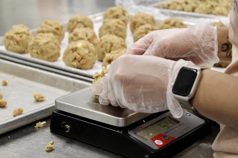 Chocolate chip cookies hand rolled and weighed on a scale