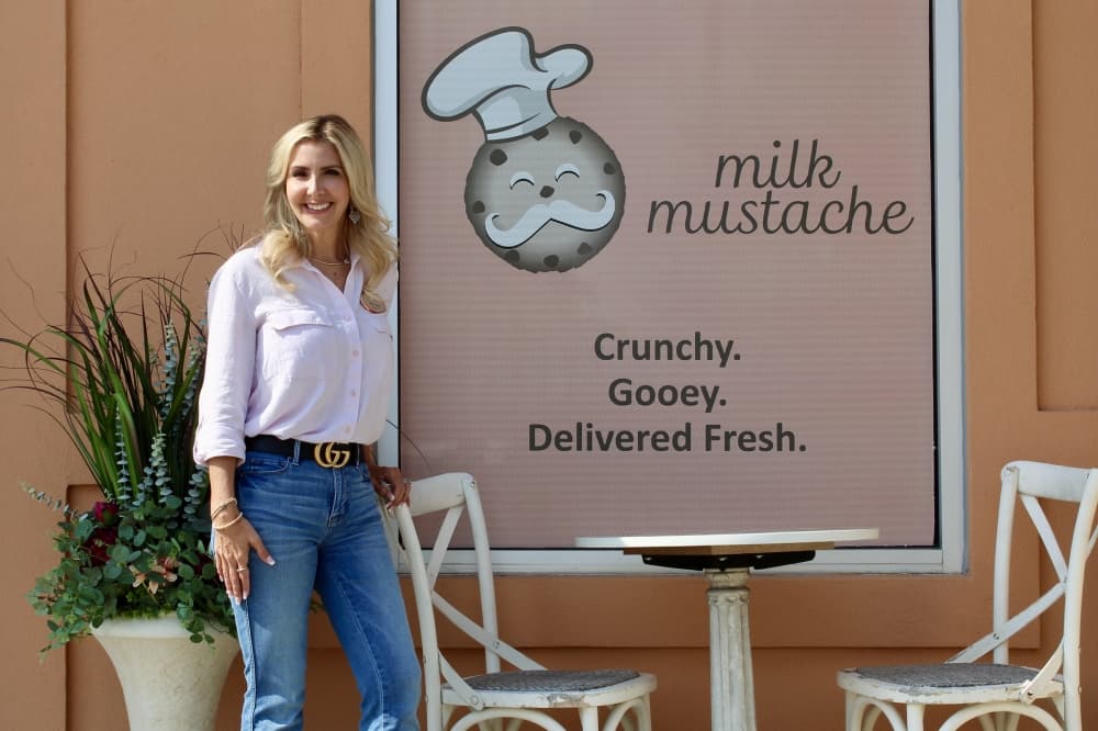 Tracy Jones outside store wit milk mustache logo in the background