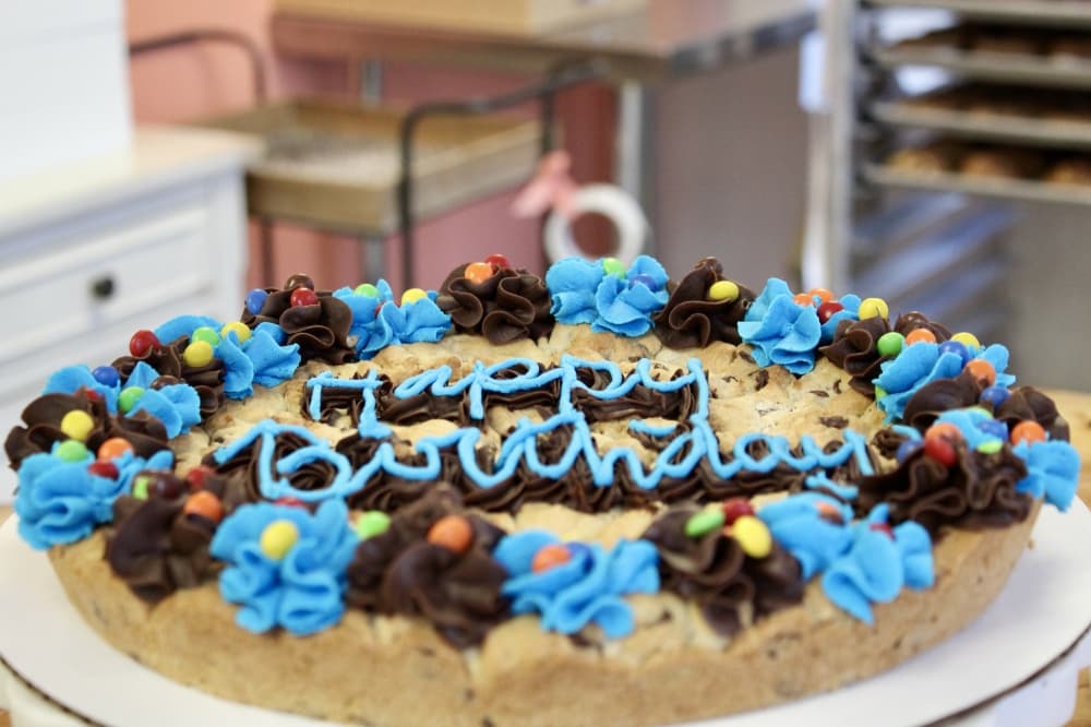 “Happy Birthday” cookie cake with blue and brown frosting