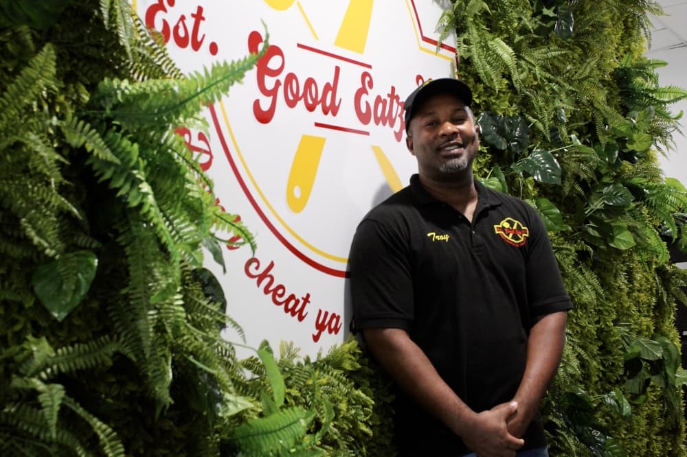 LaTroy Johnson with Good Eatz logo background and green leaves background