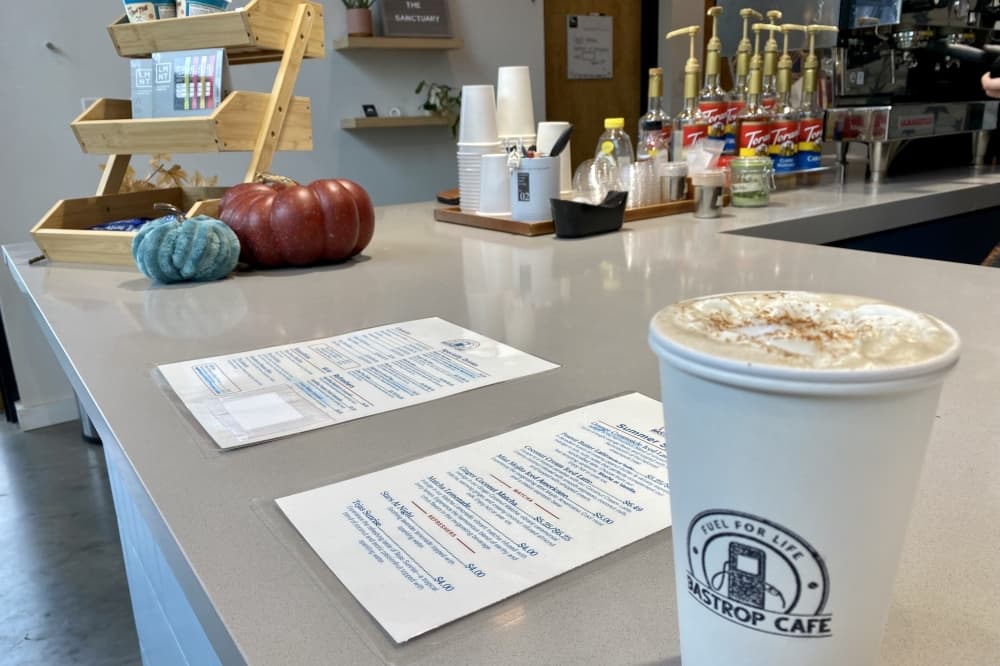 Chai latte with the Bastrop Cafe logo.