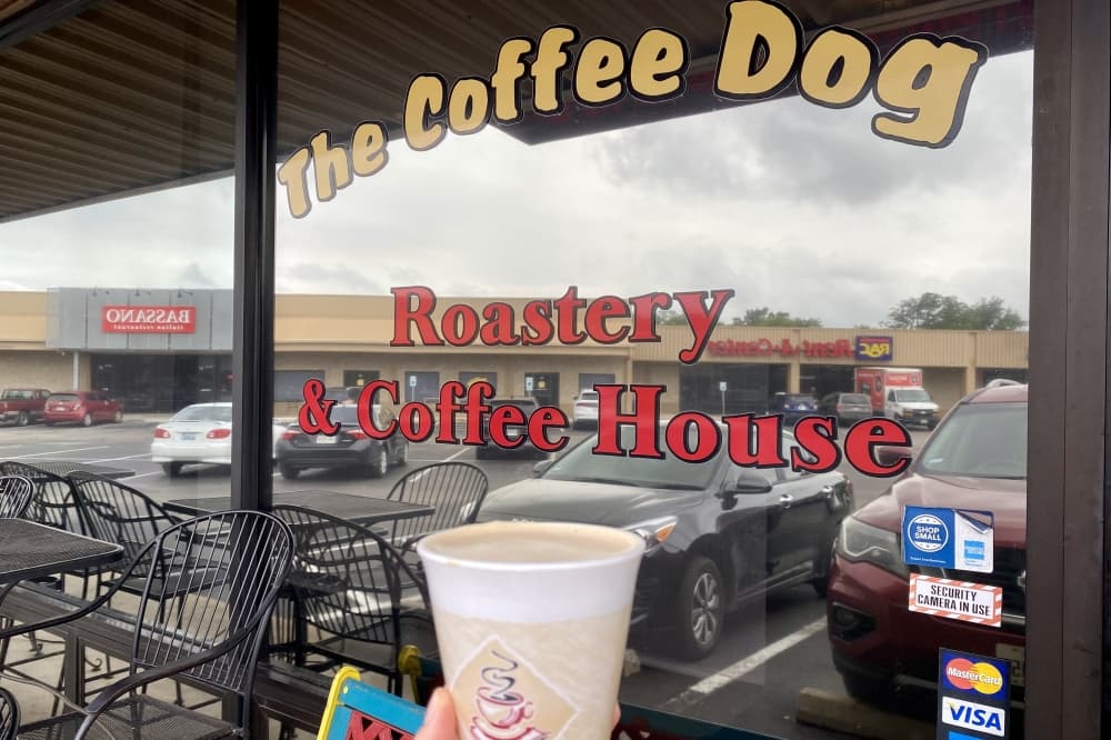 Coffee in front of Coffee Dog sign.