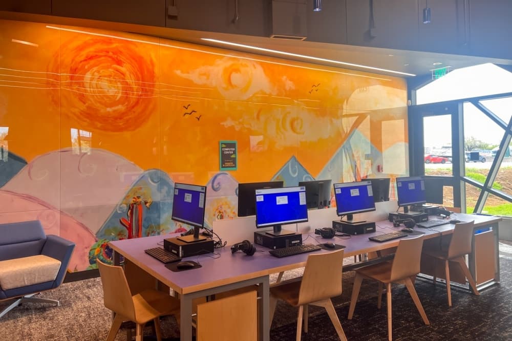 Public use computers next to a beautiful mural