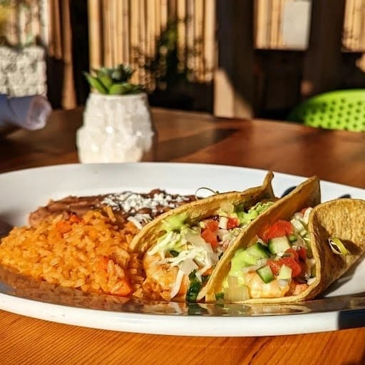 Chipotle-marinated shrimp tacos served with rice and refried beans. 