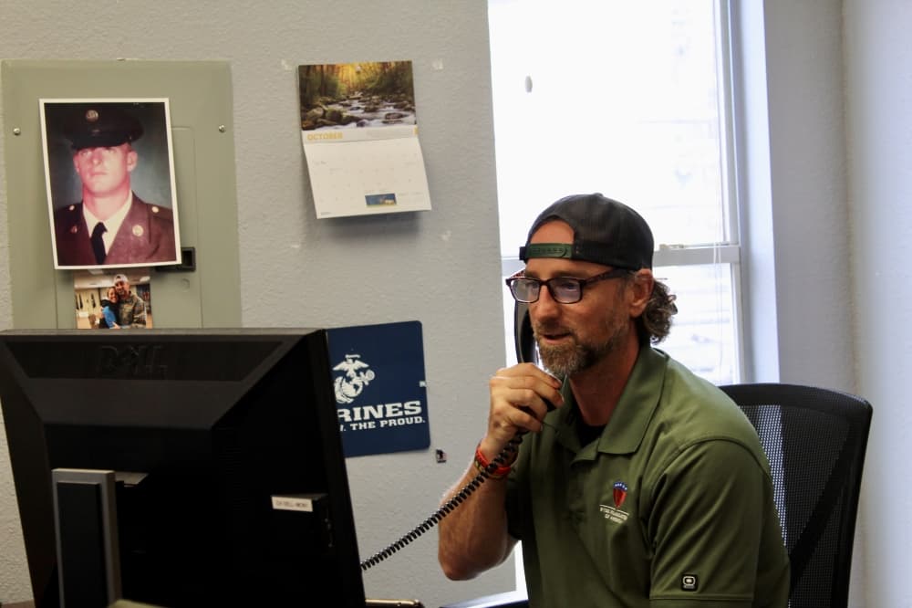 Justin Sommers at desk taking phone call
