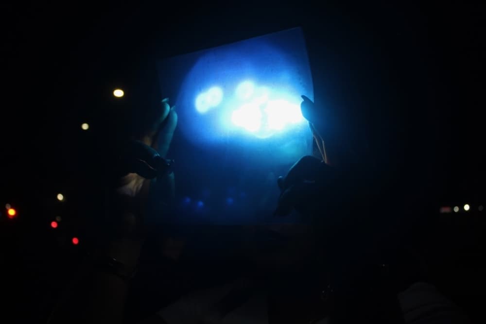 This is a picture of people in the dark using lighting objects.