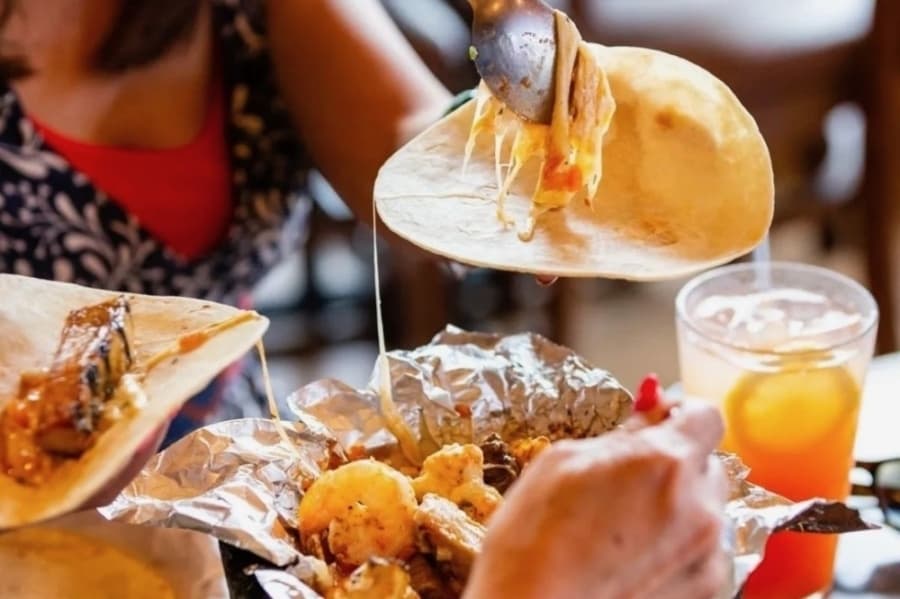 food being scooped into a tortilla