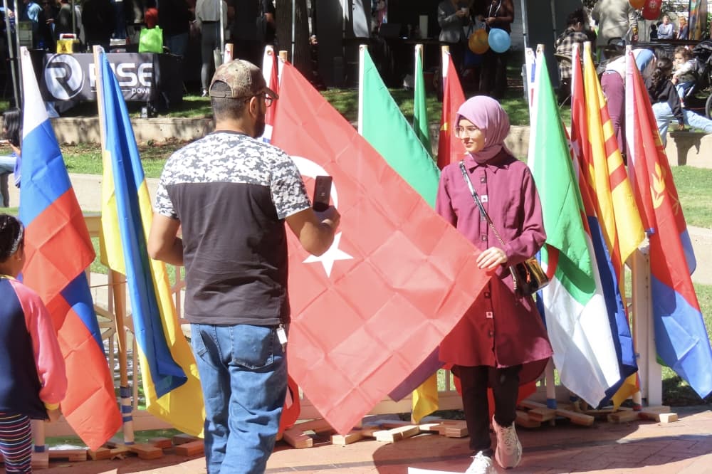 Women posed with Turkish flag at Plano International Festival. 