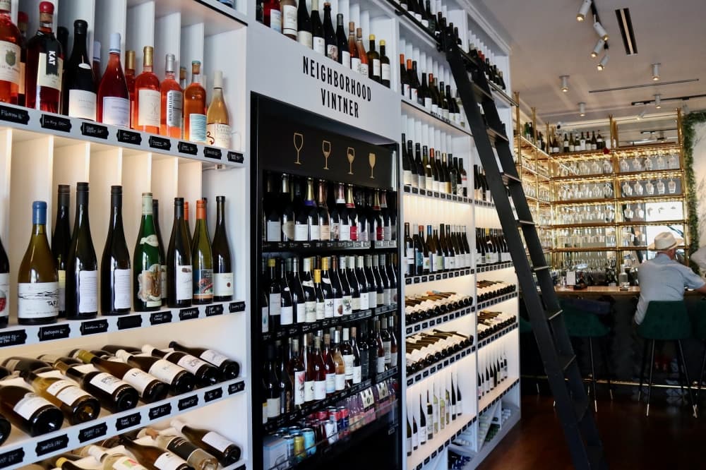 Shelves of wine and a sign that reads 'Neighborhood Vintner"