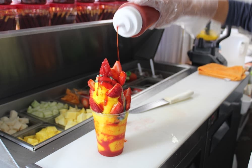 A cup of mango with toppings