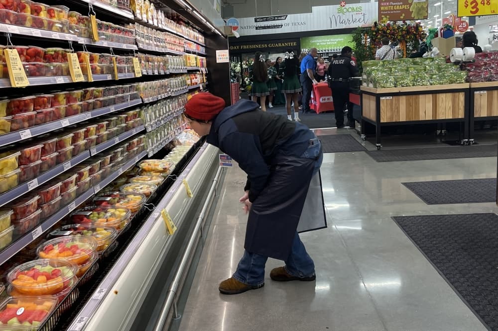An H-E-B employee looks at various products at the H-E-B in Manvel, Texas
