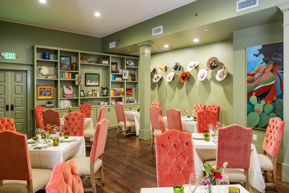 Green dining room with pink chairs