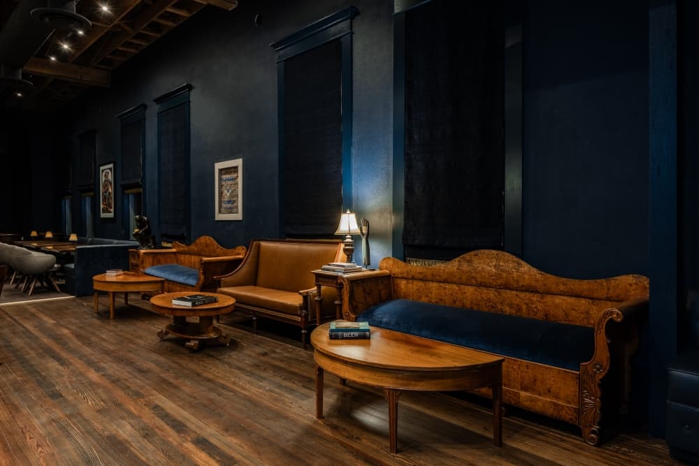 Dark blue lounge area with brown couches and tables