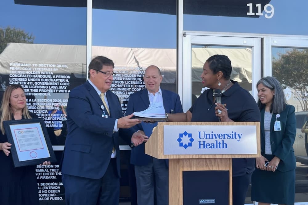 University Health President and CEO George B. Hernández Jr. accepts a ceremonial Converse sneaker at The University of Texas Health Science Center at San Antonio open house. (Tricia Schwennesen/Community Impact)
