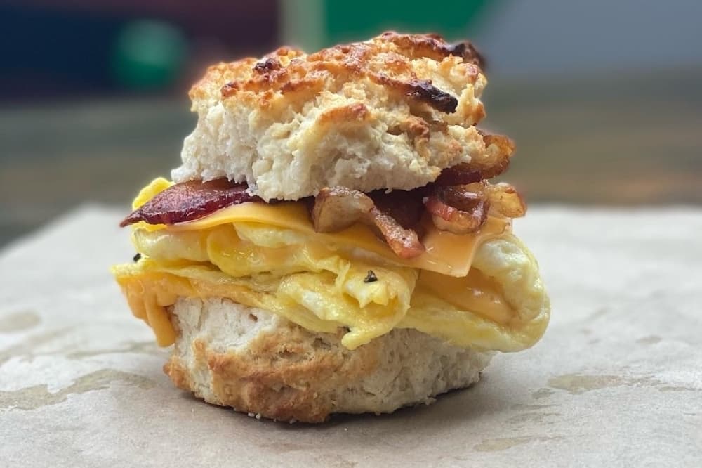A breakfast sandwich is pictured on wax paper.