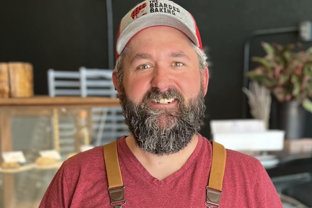 Co-owner Wesley Dills stands in front of his baked goods display case.