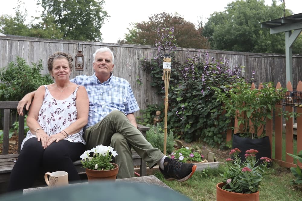 Shannon and Jeff Veazey sitting on a bench in their backyard