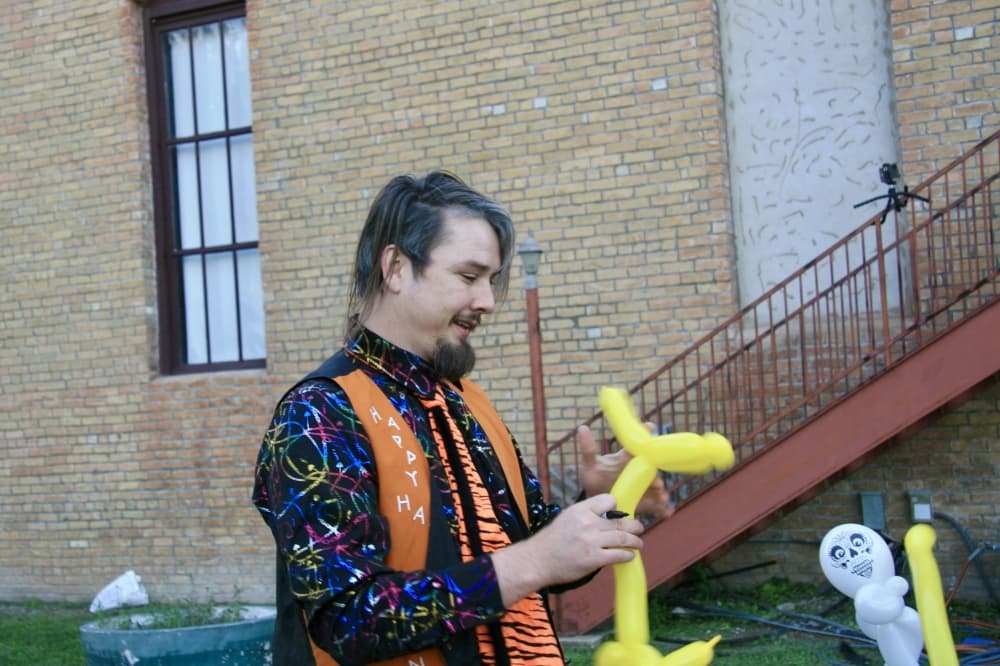 A balloon artist builds a balloon dog.