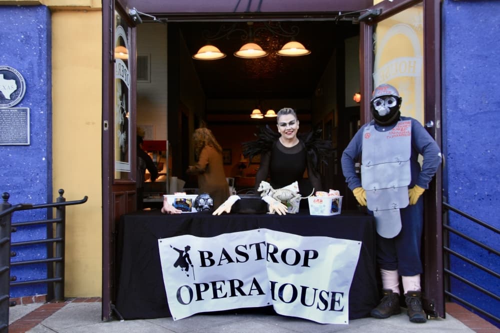 Costumed adults smile for a photo.