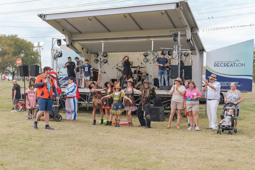 people standing in front of a stage in halloween costumes