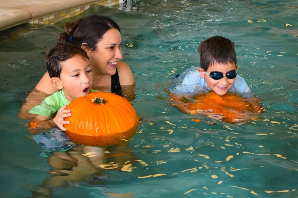 People swimming with pumpkins