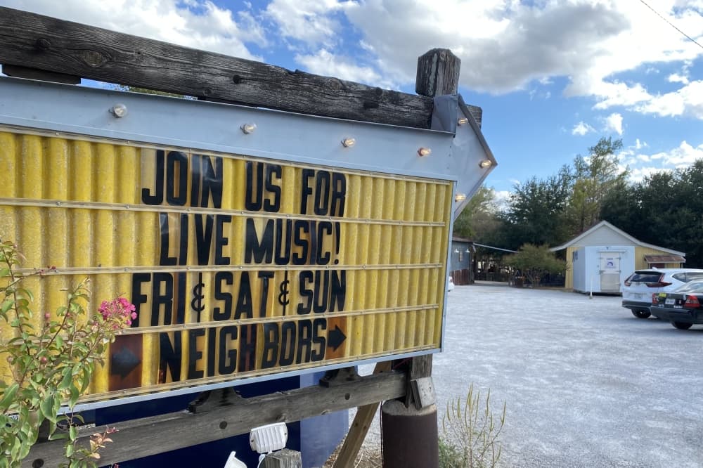 A sign reading join us for live music fri and sat and sun neighbors